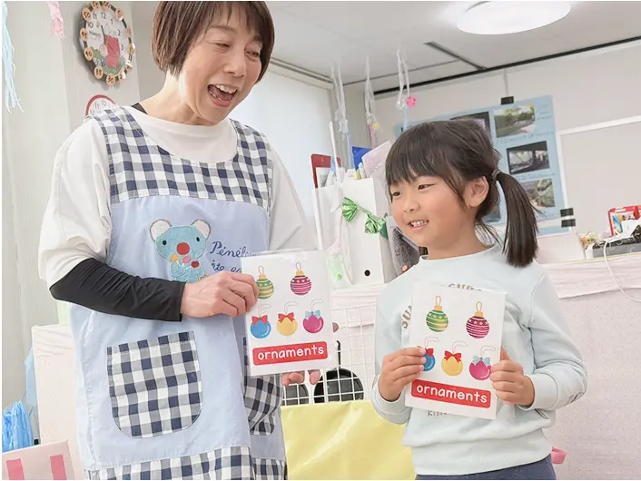 先生と子どもが英語カードを使って楽しく英語を学んでいる様子