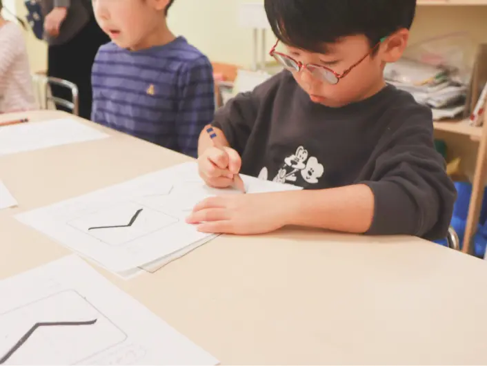 子どもが鉛筆で文字を書く練習をしている様子